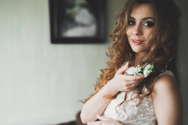 Beyaz elbiseli lüks gelin düğün törenine hazırlanırken poz veriyor.