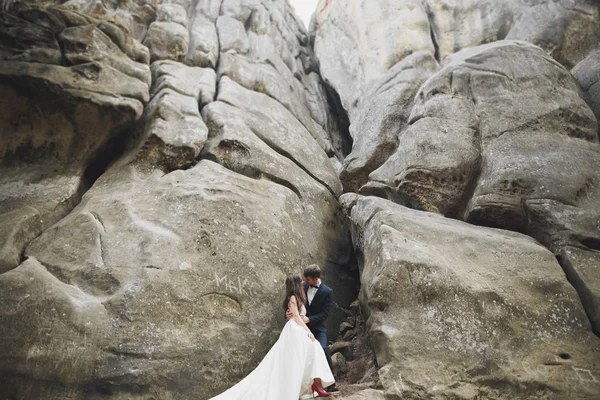 Γάμος ζευγάρι στην αγάπη φιλιά και αγκάλιασμα κοντά σε βράχους στο όμορφο τοπίο — Φωτογραφία Αρχείου