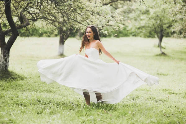 Linda noiva girando com vestido perfeito no parque — Fotografia de Stock