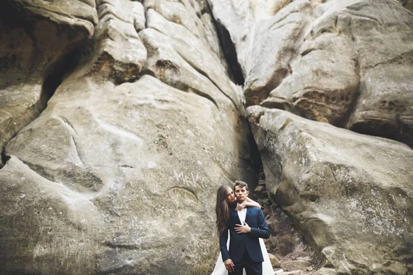 Casal feliz beijando e abraçando perto de um penhasco alto — Fotografia de Stock