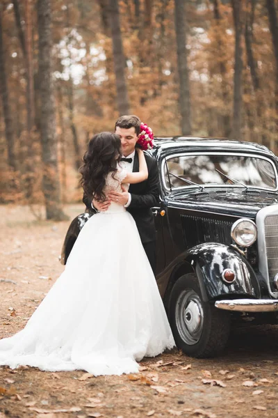 Vackra bröllop par poserar nära fantastiska retro bil — Stockfoto