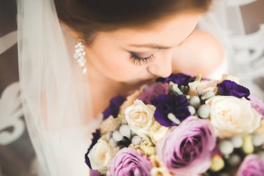 Beyaz elbiseli lüks gelin düğün törenine hazırlanırken poz veriyor.