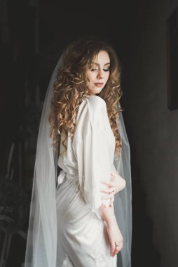 Beyaz elbiseli lüks gelin düğün törenine hazırlanırken poz veriyor.