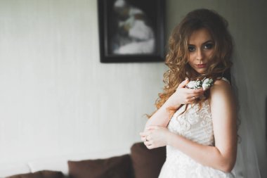 Beyaz elbiseli lüks gelin düğün törenine hazırlanırken poz veriyor.