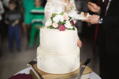 Gelin ve damat düğün pastasını kesiyor.