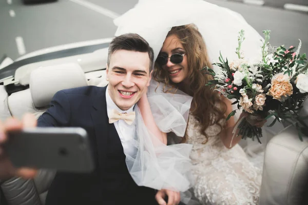 Felice sposa e sposo fare selfie al loro matrimonio in auto retrò — Foto Stock