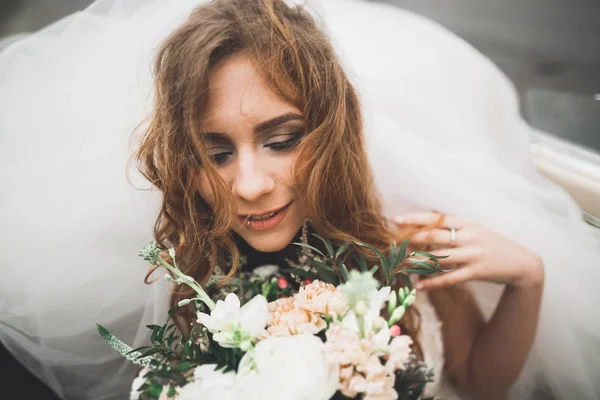 Porträt einer schönen glücklichen Braut mit Blumenstrauß — Stockfoto