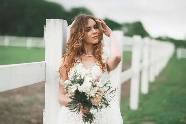 Portrait de mariée magnifique aux cheveux longs posant avec un grand bouquet — Photo
