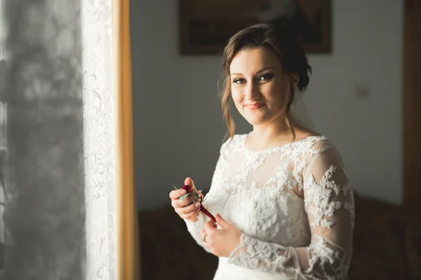 Belle mariée portant une robe de mariée de mode avec des plumes avec luxe délice maquillage et coiffure, studio séance photo d'intérieur — Photo