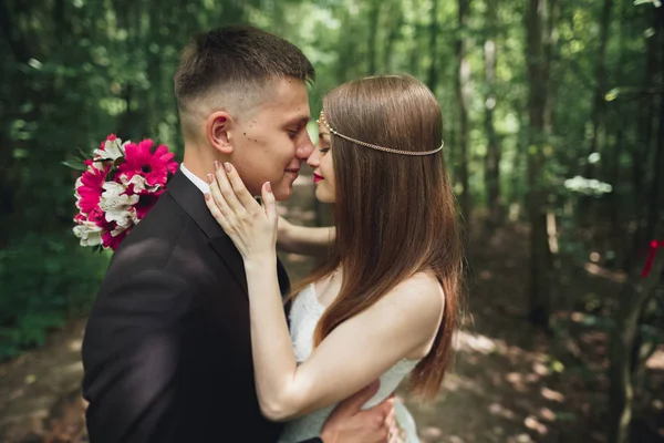 Bella giovane coppia di nozze si bacia e sorride nel parco — Foto Stock