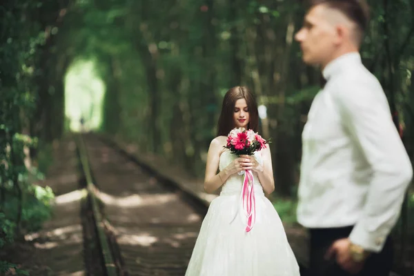 Closeup portrait of beautiful bride with wedding bouquet isolated at green natural summer field background — Stock Photo, Image