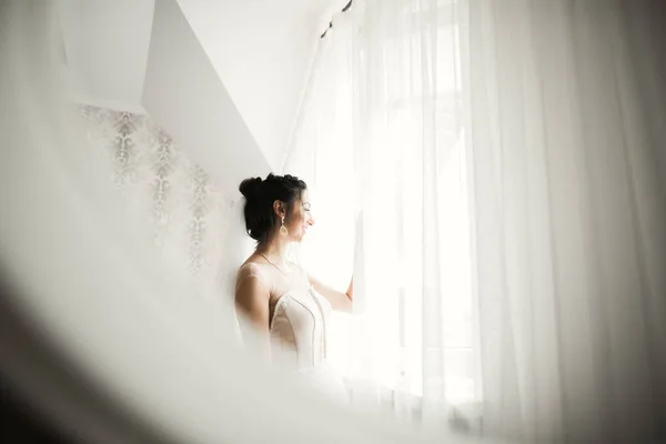 豪華な喜びのメイクアップと髪型と羽でファッションウェディングドレスを身に着けている美しい花嫁、スタジオ屋内写真撮影 — ストック写真