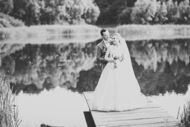 Güzel gelin ve damat evlendikleri gün kucaklaşıp öpüşüyorlar.