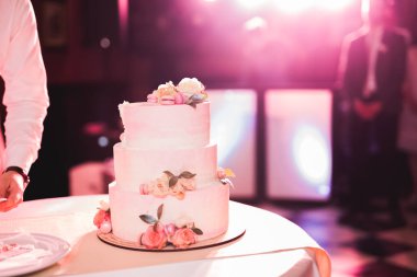 Masada süslü düğün pastası var.