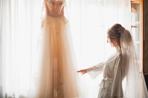 Krásná nevěsta nosí módní svatební šaty s peřím s luxusním make-up a účes, studio focení uvnitř — Stock fotografie