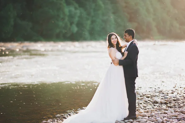 Couple de mariage, marié et mariée câlin, en plein air près de la rivière — Photo