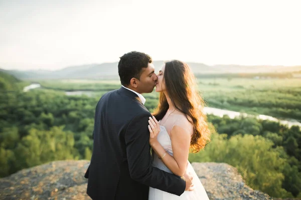 Bela noiva e noivo abraçando e beijando em seu dia de casamento ao ar livre — Fotografia de Stock