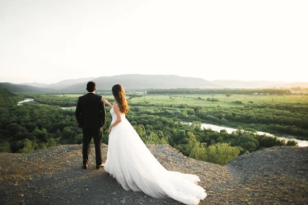 Красивая свадебная пара останавливается над красивым ландшафтом — стоковое фото