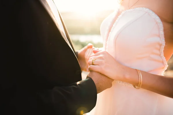 Bröllopspar håller hand, brudgum och brud tillsammans på bröllopsdagen — Stockfoto