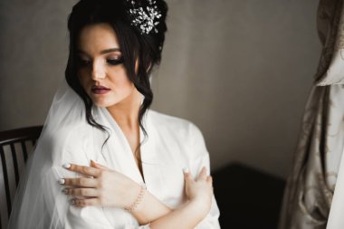 Tüylü, lüks makyaj, saç stili, stüdyo içi fotoğraf çekimi olan güzel bir gelin.