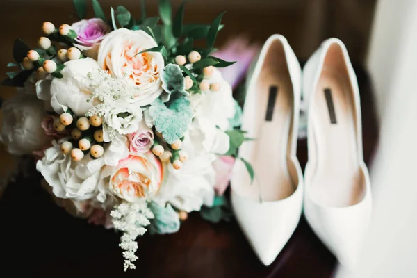 Zapatos de novia con un ramo de rosas y otras flores — Foto de Stock