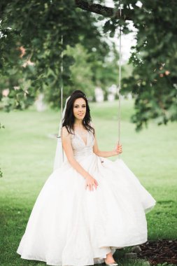 Parkta poz veren gelinlikli güzel, lüks bir gelin.