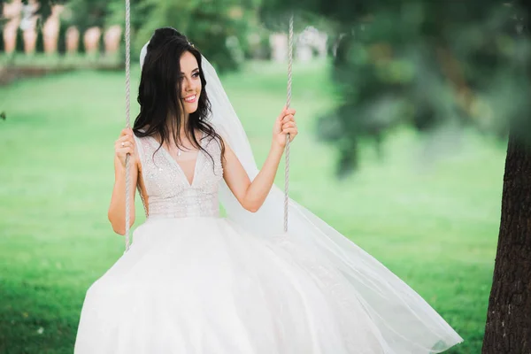 Hermosa novia joven de lujo en vestido de novia posando en el parque — Foto de Stock