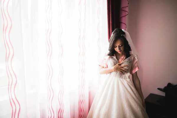 Krásná nevěsta nosí módní svatební šaty s peřím s luxusním make-up a účes, studio focení uvnitř — Stock fotografie
