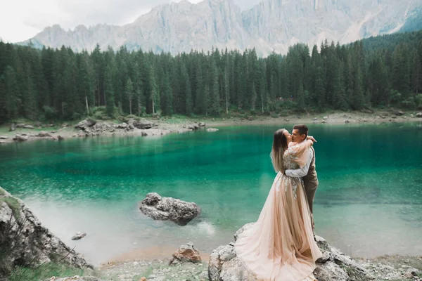 Krásný moderní pár líbání v blízkosti jezera v horách — Stock fotografie