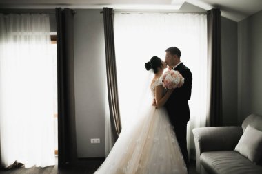 Güzel gelin ve damat düğün günlerinde kucaklaşıp öpüşürler.