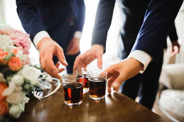 Incontro d'affari. Gli uomini tengono bicchieri di whisky. Festa degli uomini. Mano con una bevanda alcolica — Foto Stock