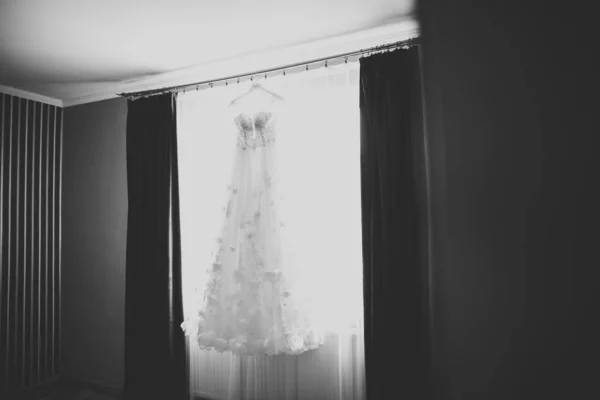 Идеальное свадебное платье с полной юбкой на вешалке в комнате невесты — стоковое фото