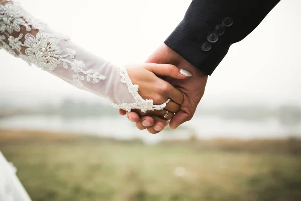 Свадебная пара держась за руки, жених и невеста вместе в день свадьбы — стоковое фото