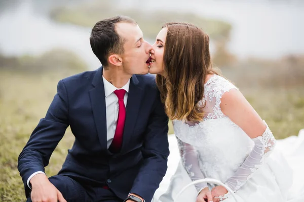 Hermosa novia y novio abrazar y besar en su boda al aire libre — Foto de Stock