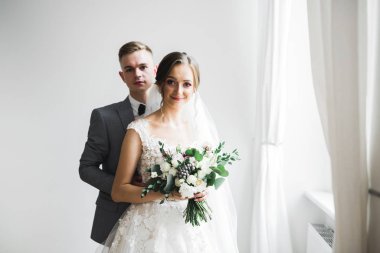 Doğadaki düğün çifti birbirine sarılıyor. Beyaz elbiseli güzel bir kız. Takım elbiseli adam