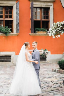 Doğadaki düğün çifti birbirine sarılıyor. Beyaz elbiseli güzel bir kız. Takım elbiseli adam