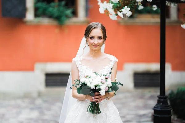 Krásný portrét nevěsty na sobě módní svatební šaty s peřím s luxusní potěšení make-up a účes — Stock fotografie