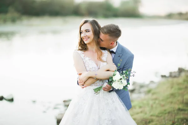 Couple de mariage, marié et mariée câlin, en plein air près de la rivière — Photo