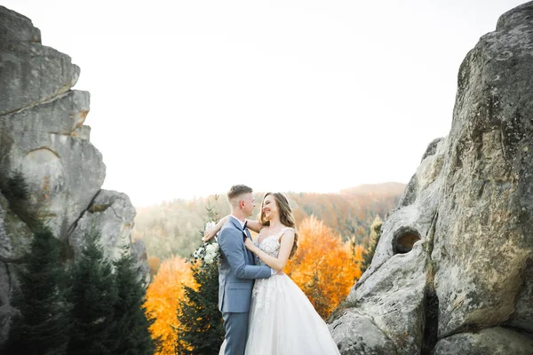 Cantik pengantin dengan buket di gunung latar belakang saat matahari terbenam — Stok Foto