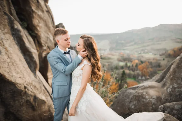美丽华丽的新娘向新郎摆姿势，在高山边玩乐，美丽的景色，文字的空间，新婚夫妇 — 图库照片
