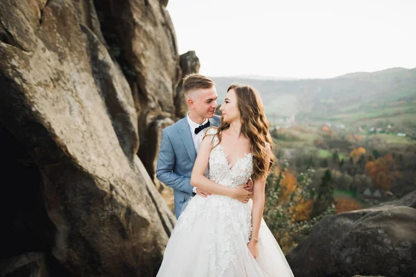 Couple de mariage sur la nature se serre dans ses bras. Belle fille modèle en robe blanche. Homme en costume — Photo