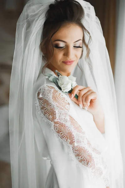 Schöne Luxusbraut im eleganten weißen Kleid hält Blumenstrauß in den Händen — Stockfoto