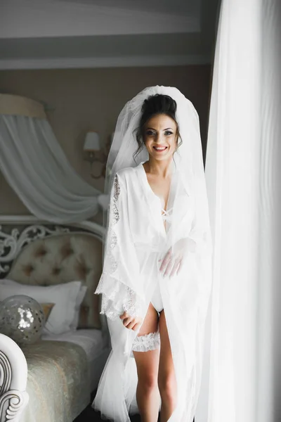 Schöne Braut trägt Mode Hochzeitskleid mit Federn mit luxuriösem Genuss Make-up und Frisur, Studio Indoor Fotoshooting — Stockfoto