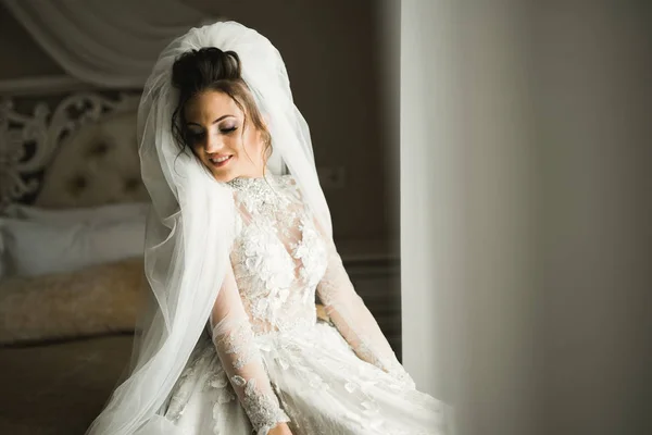 Retrato de belleza de la novia con vestido de novia de moda con plumas con maquillaje y peinado de lujo deleite — Foto de Stock