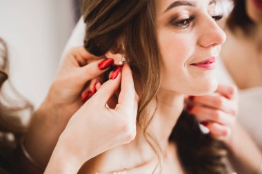 Cüppeli muhteşem gelin bir odada düğün töreni için poz veriyor ve hazırlanıyor.