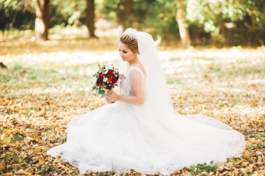 Gelin çiçekli büyük ve güzel bir düğün buketi tutuyor.