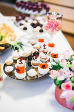 Lezzetli ve tatlı bir tatlı masası. Kapalı resepsiyonda küçük kekler ve shot 'lar var.