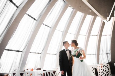 Güzel gelin ve damat düğün günlerinde kucaklaşıp öpüşürler.