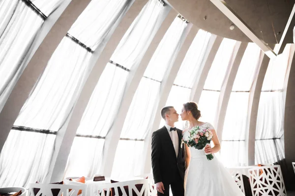 Güzel gelin ve damat düğün günlerinde kucaklaşıp öpüşürler.