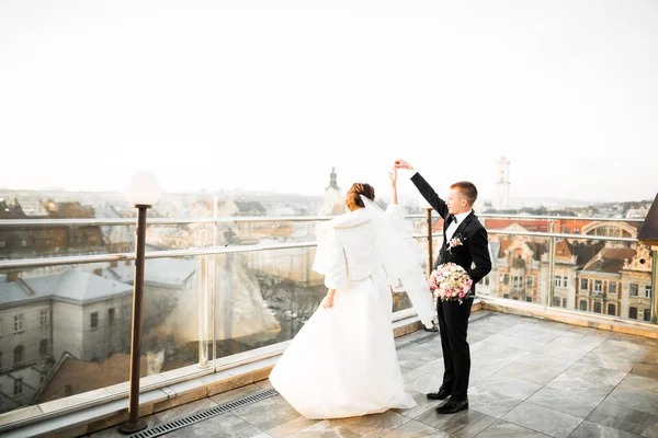 Hermosa pareja de boda bailando en un balcón — Foto de Stock